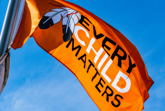 An orange flag with eagle feathers and the words 