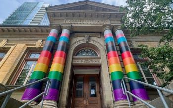 Toronto Public Library’s Yorkville Branch with transgender and rainbow flags wrapped on the pillars.